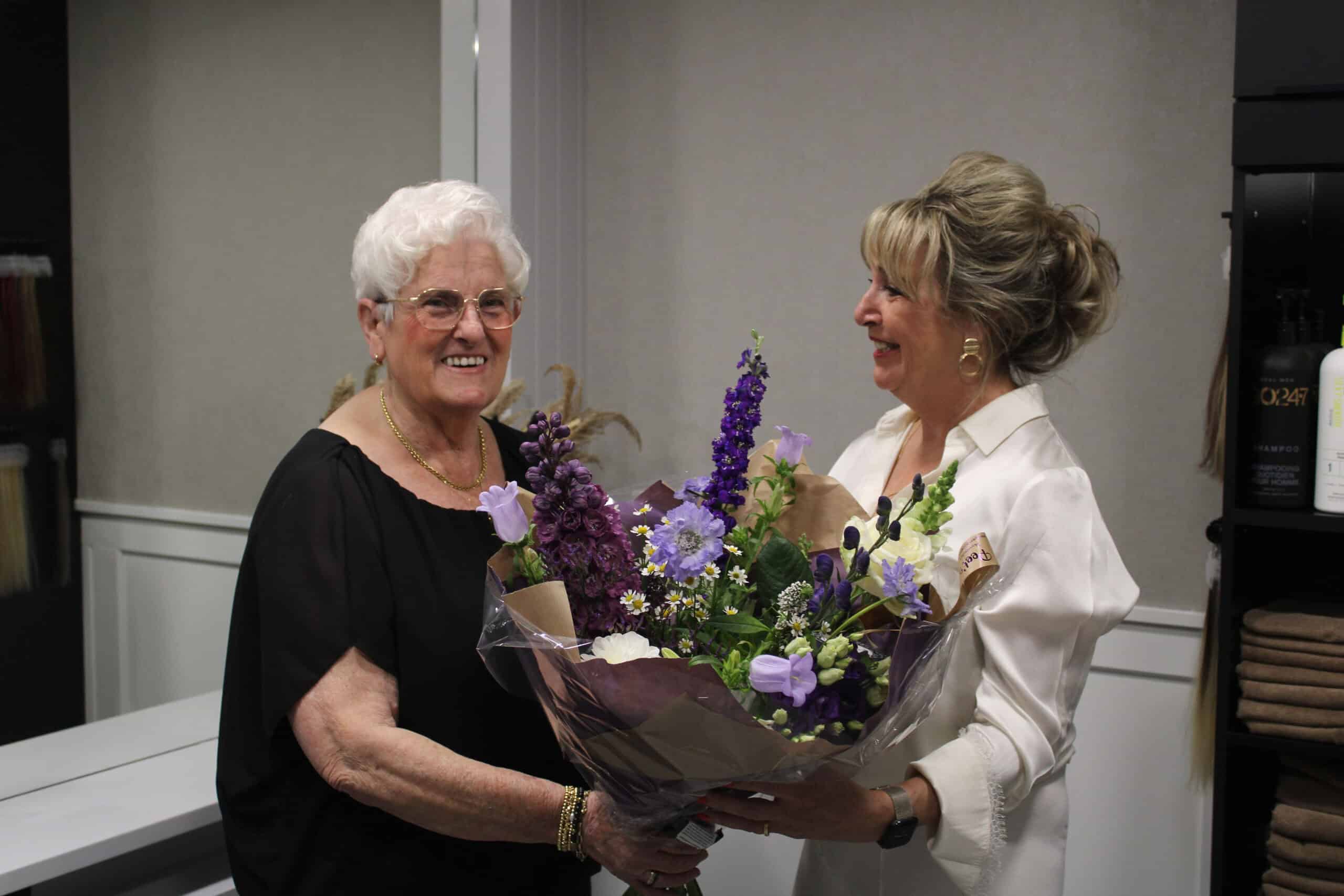Marleen ontvangt bloemen van een klant bij Hairnation