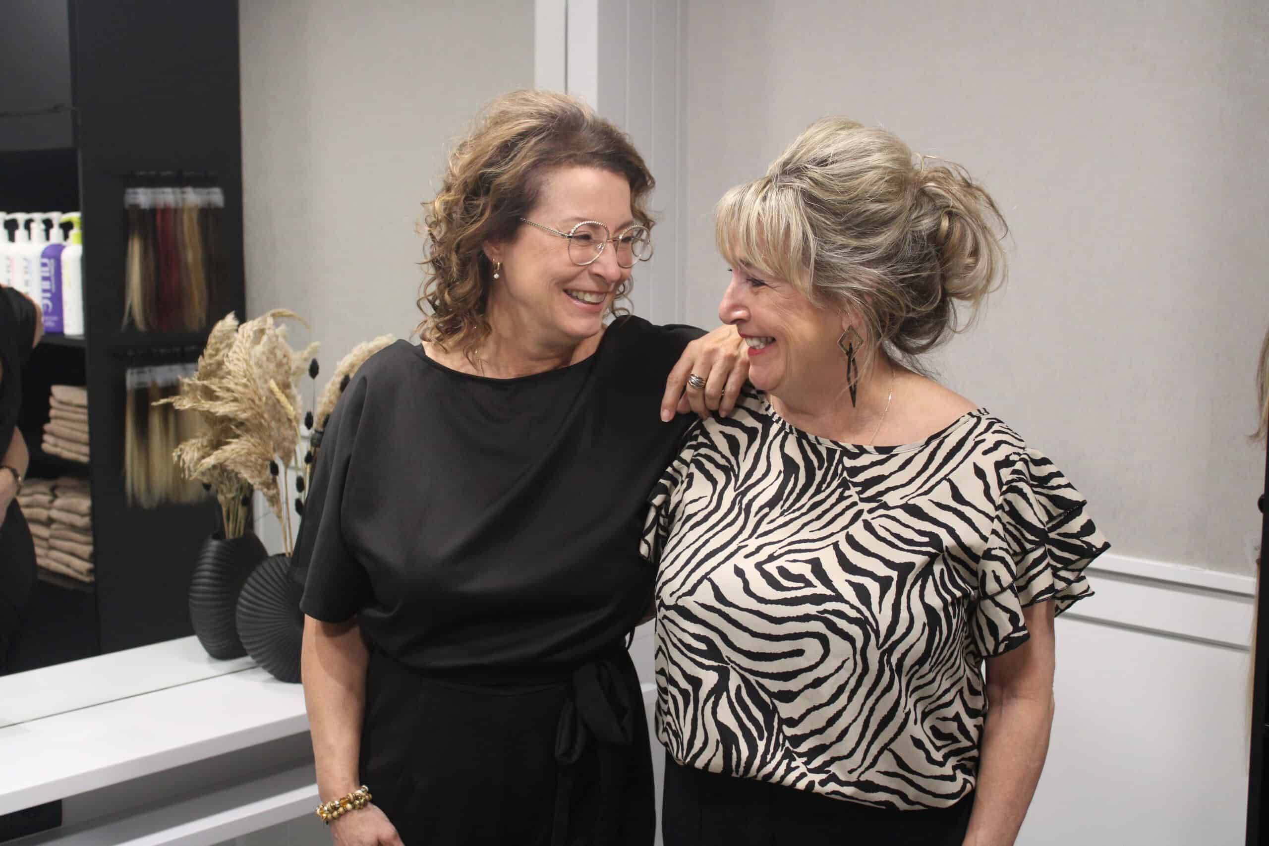 Eigenaar van Hairnation lacht samen met een tevreden klant.